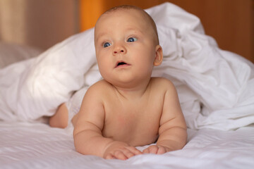 baby on bed with white sheets