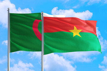 Fototapeta na wymiar Burkina Faso and Algeria national flag waving in the windy deep blue sky. Diplomacy and international relations concept.