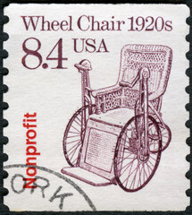 Fototapeta na wymiar USA - 1987: shows Wheel Chair 1920s, series Transportation Coils series, 1987