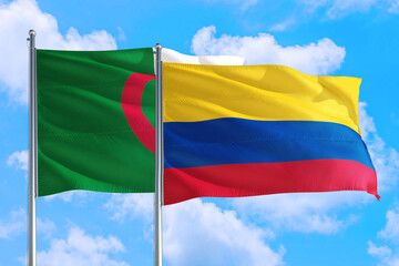 Colombia and Algeria national flag waving in the windy deep blue sky. Diplomacy and international relations concept.