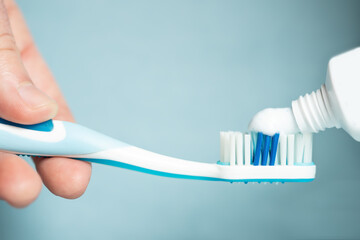 Young woman holding a blue toothbrush