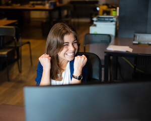 Joyful woman at her desk in the office