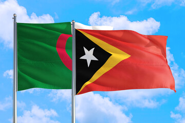 East Timor and Algeria national flag waving in the windy deep blue sky. Diplomacy and international relations concept.