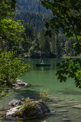 Berchtesgaden lake Hintersee with trees in foreground and mountains in the background on a summer day