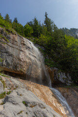 Berchtesgaden waterfall under the cliffs on a summer day at lake Königssee