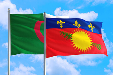 Guadeloupe and Algeria national flag waving in the windy deep blue sky. Diplomacy and international relations concept.
