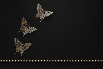 Decorative butterflies on a black background, a composition with three butterflies on the table