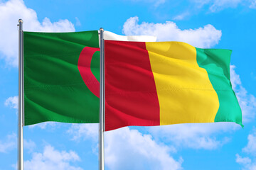Guinea Bissau and Algeria national flag waving in the windy deep blue sky. Diplomacy and international relations concept.