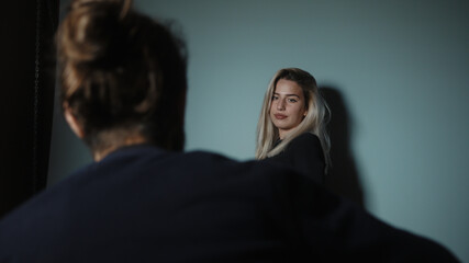 Young blonde woman poses against photographer in studio environment, fashion, magazine and studio photography concept