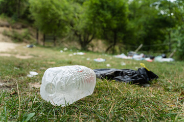 Pollution in nature - garbage thrown on the field covering grass - trash in the countryside on...