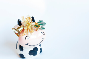 Bull's piggy Bank decorated with Christmas decorations on a white background. New year of the bull. Symbol of the new year of the bull