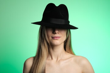 Girl in a black hat on a green background