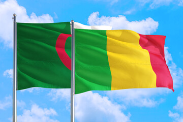 Mali and Algeria national flag waving in the windy deep blue sky. Diplomacy and international relations concept.