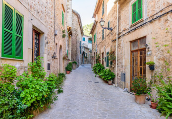 beautiful street with stone buildings decorated with flowers in Valldemossa old town, Mallorca island, Spain