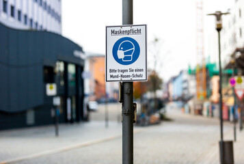 Info sign in a german city with german text. Maskenpflicht, Bitte tragen Sie einen...
