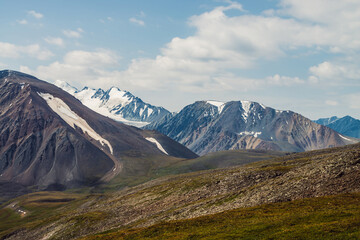 Scenic landscape with great mountain range and glacier. Snow on top of giant mountain ridge. Beautiful big snowy mountains in sunny day. View from pass to snowy peak and glacial mounts in sunlight.
