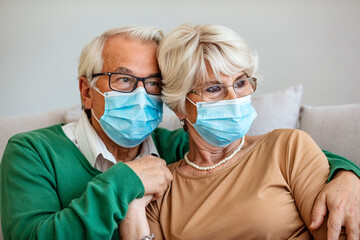 Portrait of couple elder senior old male and female wearing face medical mask. pandemic coronavirus disease quarantine in home. Covid-19 outbreak prevention concept.