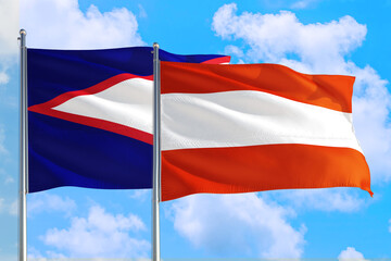 Fototapeta na wymiar Austria and American Samoa national flag waving in the windy deep blue sky. Diplomacy and international relations concept.