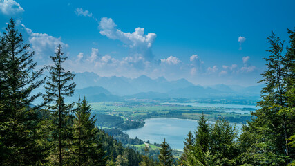 Germany, Allgaeu, Buchenberg view on 3 lakes of bannwaldsee, forgensee, hopfensee and fuessen city next to panorama of the alps mountains