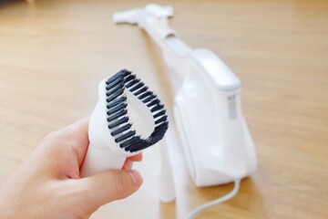 His hand and Her hand holding the equipment for the Vacuum cleaner/Woman use vacuum cleaner. Close up.