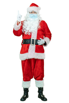 Santa wear in a covid medical mask, shows index finger up. Full body Santa Claus is showing index finger iup on white background. Christmas coming