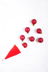 Red baubles rolling out of the santa hat against the white background. Flapper imitation. Christmas composition