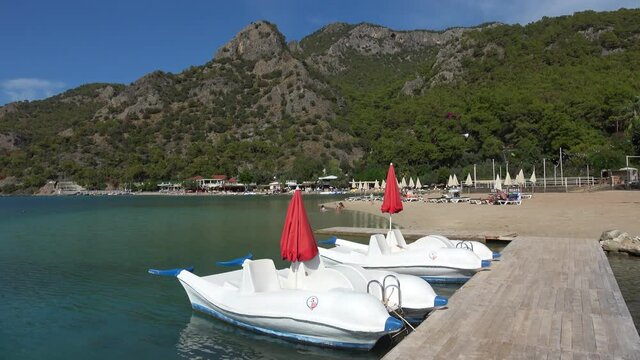 Oludeniz beach, Fethiye, Turkey - 24th of October 2020: 4K Water bicycles and few people on the Blue lagoon beach
