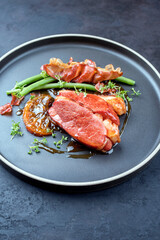Modern Style Gourmet Entenbrust Filet mit Bohnen und Orangen Relish angeboten als close-up auf einem Nordic Design Teller