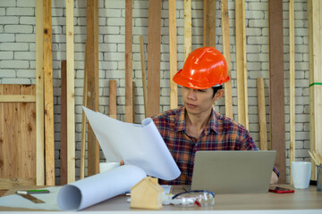 professional Asian Engineer with protective hard hat safety work in workshop wood plank...