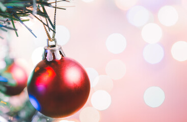 Christmas decoration. Red balls hanging on pine branches christmas tree garland and ornaments over abstract bokeh background with copy space