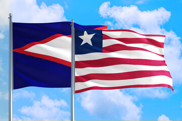 Liberia and American Samoa national flag waving in the windy deep blue sky. Diplomacy and international relations concept.