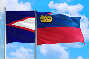 Liechtenstein and American Samoa national flag waving in the windy deep blue sky. Diplomacy and international relations concept.