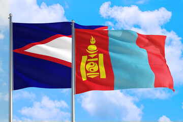 Mongolia and American Samoa national flag waving in the windy deep blue sky. Diplomacy and international relations concept.