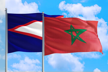 Morocco and American Samoa national flag waving in the windy deep blue sky. Diplomacy and international relations concept.