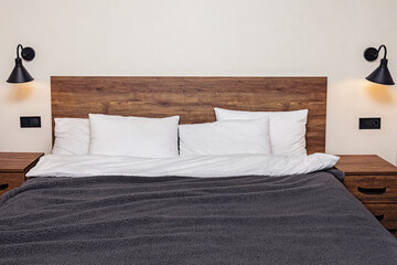 Fototapeta na wymiar Modern minimalist bedroom interior. Bed with wooden headboard white pillows