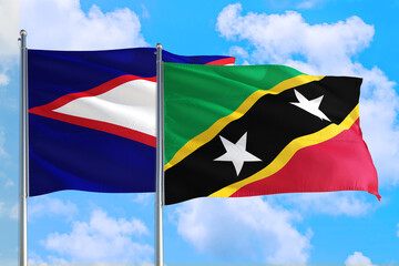 Saint Kitts And Nevis and American Samoa national flag waving in the windy deep blue sky. Diplomacy and international relations concept.