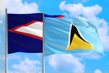 Saint Lucia and American Samoa national flag waving in the windy deep blue sky. Diplomacy and...