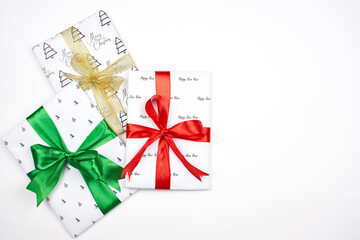 X-mas gift wrapped in paper with Christmas prints and tied with black ribbon. Christmas present box on white background