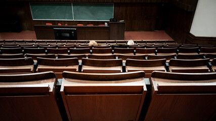 Upper seats row in university style auditorium. Blurred background.