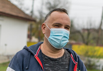 The man puts a medical mask on his face. Wearing a medical mask during a coronavirus pandemic.