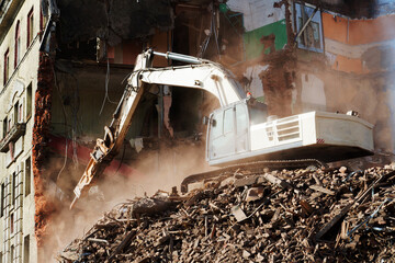 excavator demolishing a brick building. Machinery Demolishing Building