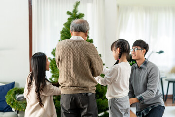 Obraz premium Multigenerational Family decorating a Christmas tree for season greeting.
