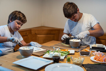 two teenagers make sushi themselves at home