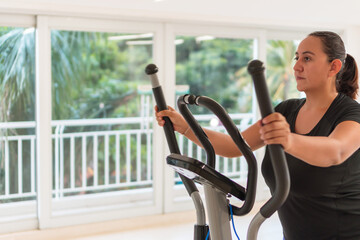 Woman working on home elliptical trainer
