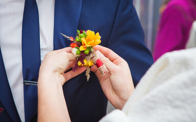 bride groom wears a buttonhole