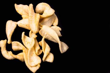 Delicious crispy potato chips Top view close up look isolated on black background
