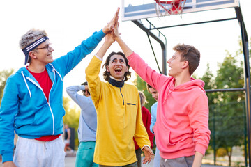 young basketball team give high five to each other, celebrate the win, happy caucasian teens congratulate