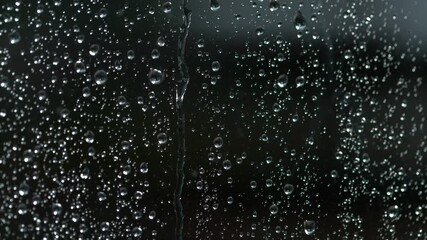 SLOW MOTION, MACRO, DOF: Raindrop trickles down a wet window during a rainstorm. clear raindrops accumulate on the windowpane and trickle down the glass. Droplets of fresh rainwater on a window. - Powered by Adobe