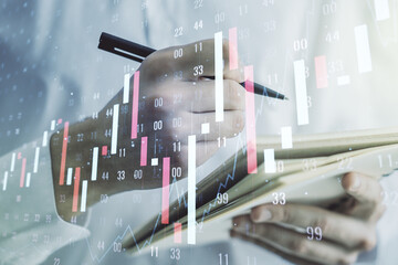 Abstract creative financial graph with hand writing in notebook on background, forex and investment concept. Multiexposure