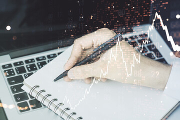 Multi exposure of abstract creative financial chart with world map and with hand writing in notebook on background with laptop, research and analytics concept